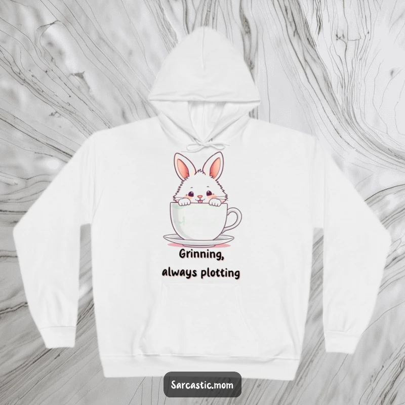Funny fluffy bunny peeking over a steaming teacup with a mischievous grin, printed on a warm hoodie.