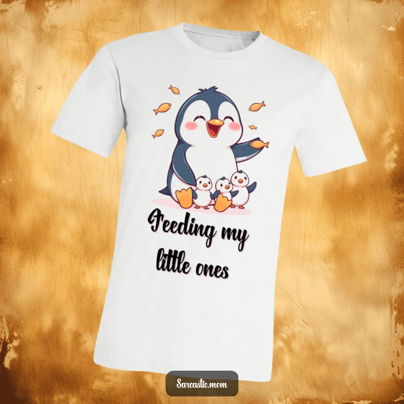 Funny T-Shirt: A happy penguin mom expertly juggling small fish for her hungry chicks, a sweet and humorous depiction of motherhood.